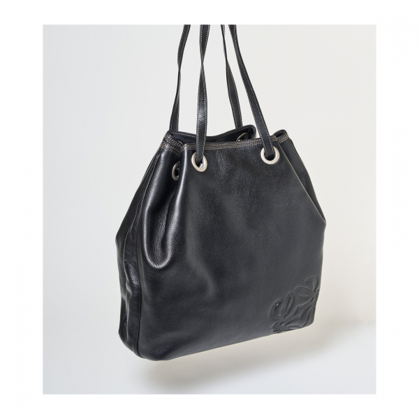 LOEWE. Bolso en cuero de tonalidad negra de cierre tipo saco con costuras en hilo blanco y logotipo de la firma grabado en relieve sobre la piel.