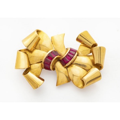 Broche Chevalier en oro amarillo en forma de lazo con rubíes.