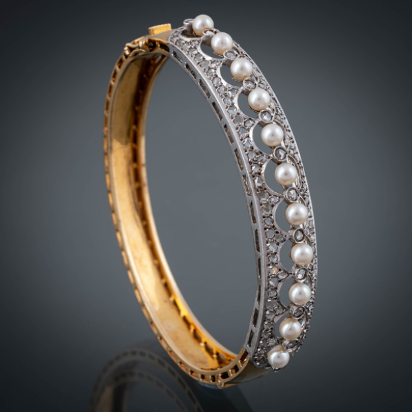 Brazalete r&iacute;gido con abertura en oro amarillo de 18 kt con brillantes talla antigua y perlas.