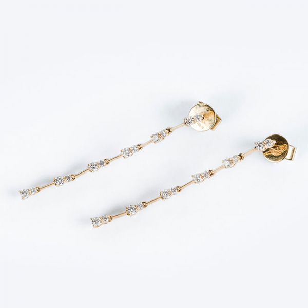 Pendientes largos en oro amarillo 18 K, en fila articulada con pares de limpios y blancos diamantes, talla brillante