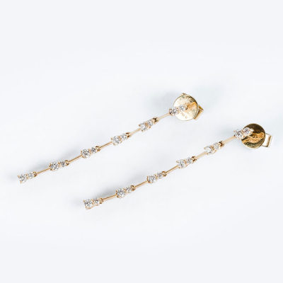 Pendientes largos en oro amarillo 18 K, en fila articulada con pares de limpios y blancos diamantes, talla brillante