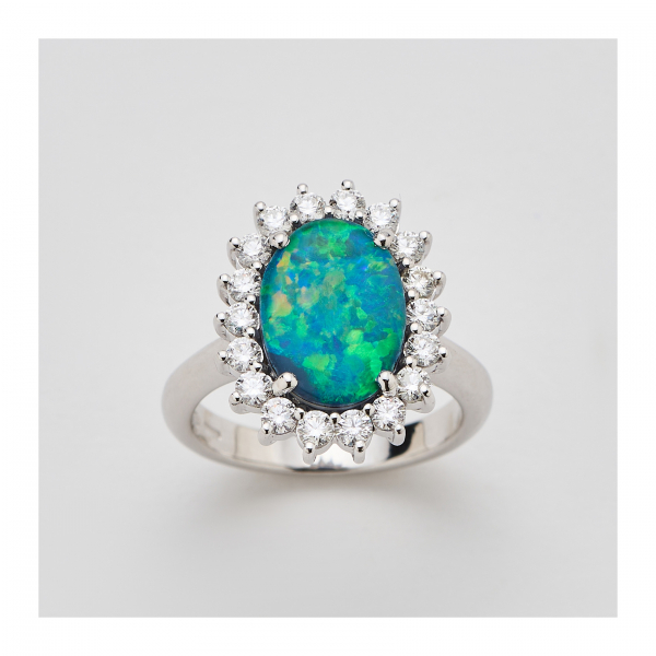 Sortija rosetón en oro blanco con ópalo australiano talla oval de 12 x 9 mm. orlado por diamantes talla brillante.