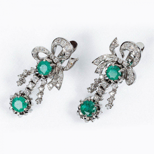 Pendientes largos vintage en sólida montura de oro blanco 18 K con motivo de lazada y 'flecos' colgantes, con centros de bonitas esmeraldas naturales, y limpios y blancos diamantes 