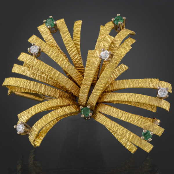 Broche en forma de flor en oro amarillo de 18 kt con brillantes y esmeraldas.
