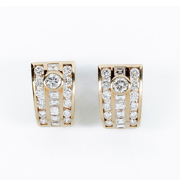 Pendientes de alta joyería en sólida montura de oro amarillo 18 K con un limpio y blanco diamante talla brillante central sobre banda y filas de diamantes 