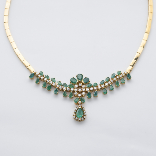 Gargantilla de eslabones rectangulares planos en oro con centro de esmeraldas talla perilla y diamantes talla brillante engastados en garras.