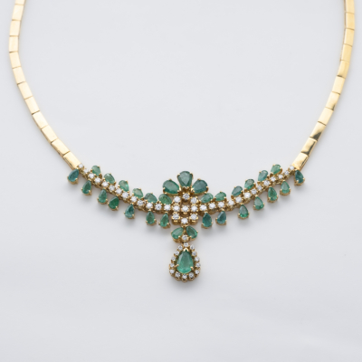 Gargantilla de eslabones rectangulares planos en oro con centro de esmeraldas talla perilla y diamantes talla brillante engastados en garras.