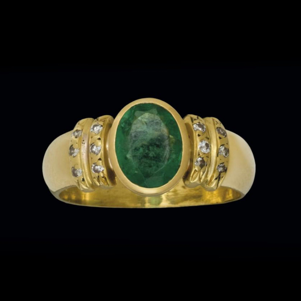 Anillo de oro amarillo de 18 K. con esmeralda colombiana talla oval y diamantes 