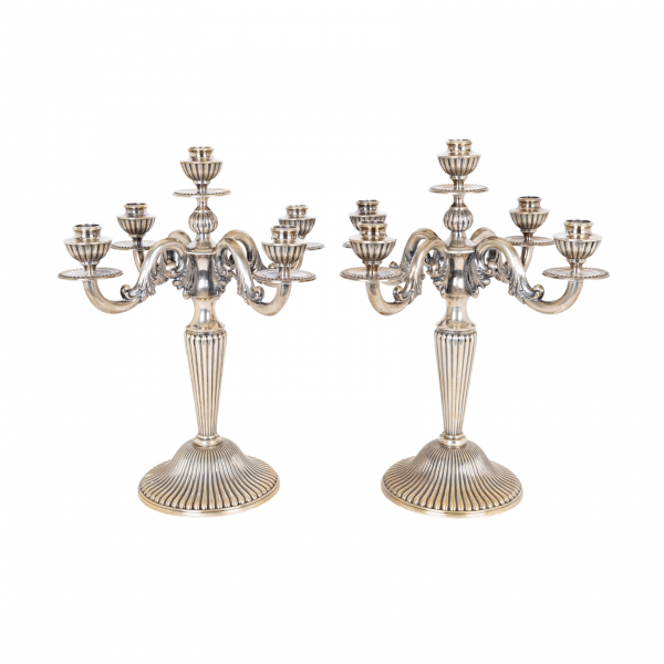 Pareja de candelabros de cinco luces en plata española punzonada con decoración de gallones y motivos vegetales, c.1940.