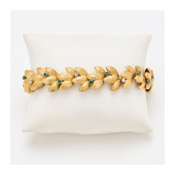 Pulsera diseño hojas en oro mate con decoración de diamantes talla brillante y esmeraldas talla redonda engastados en garras.