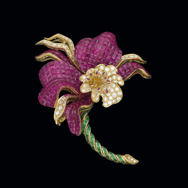 Extraordinario broche de oro amarillo de 18 K. realizado en forma de flor con rubíes talla carré, diamantes y esmeraldas