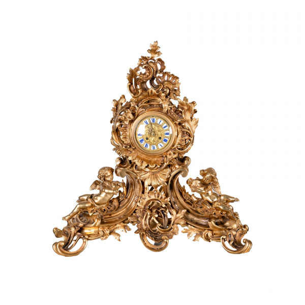 Reloj de sobremesa estilo Luis XV en bronce dorado con decoraci&oacute;n floral, de rocallas, roleos y acantos, custodiado por pareja de puttis, s.XIX.