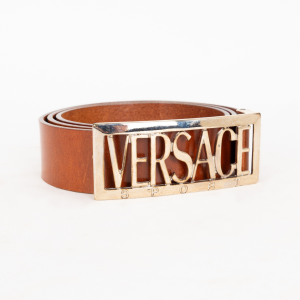 VERSACE SPORT. Cinturón en cuero de tonalidad marrón camel con cierre con logotipo en metal dorado.  