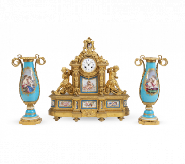 "Raingo Freres A Paris".  Guarnición de chimenea de bronce dorado y porcelana esmaltada a la Manera de Sévres.  Francia, último cuarto del S. XIX. 