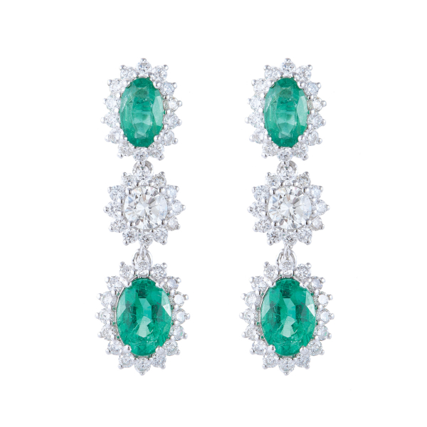 Pendientes en oro blanco con tres rosetones de diamantes talla brillante, dos de ellos con esmeralda central talla oval.