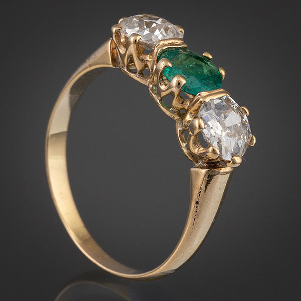 Anillo tresillo en oro amarillo de 18kt con esmeralda central y dos brillantes.