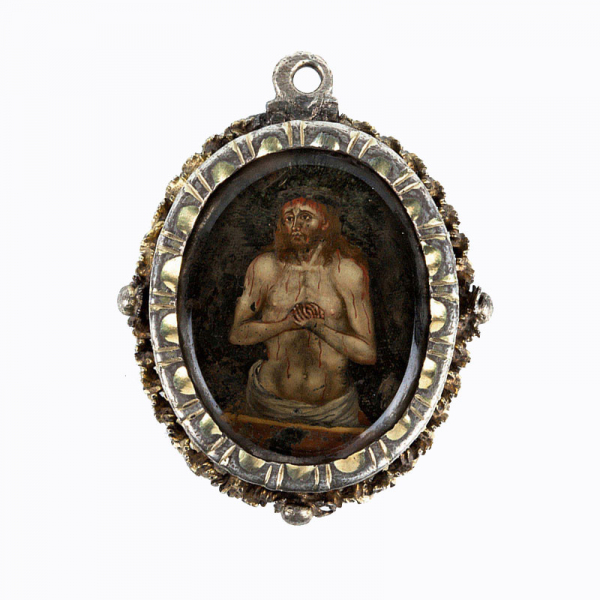 Colgante relicario, oval, en montura de plata y plata dorada, con delicadas miniaturas policromadas en anverso y reverso, sobre placa de cristal ( 45 x 35 mm) de Santa Teresa y el Cristo resucitado.