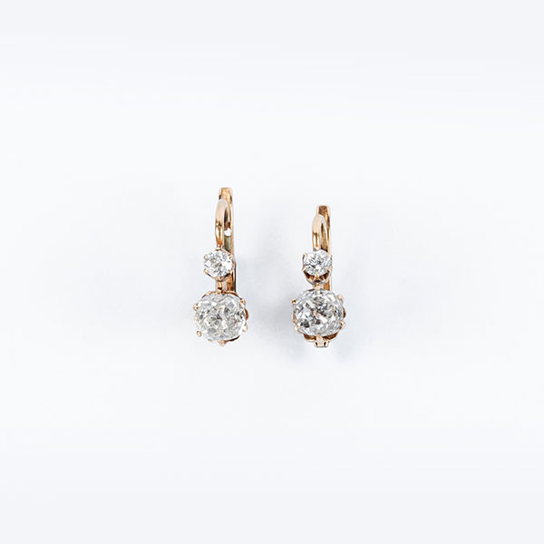Bonitos pendientes zarcillo antiguos en montura de oro amarillo 18 K con dos limpios y blancos diamantes naturales, talla 'cushion' antigua, en garras
