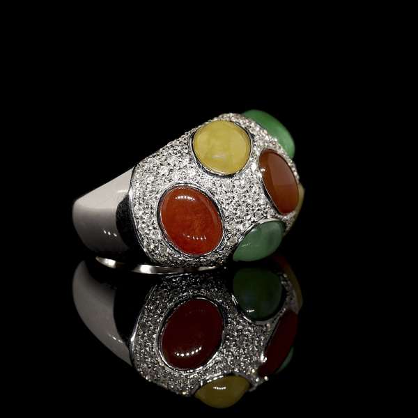 Anillo de oro blanco de 18k con diamantes y jadeíta de tres colores, con contrastes visibles en su interior. 