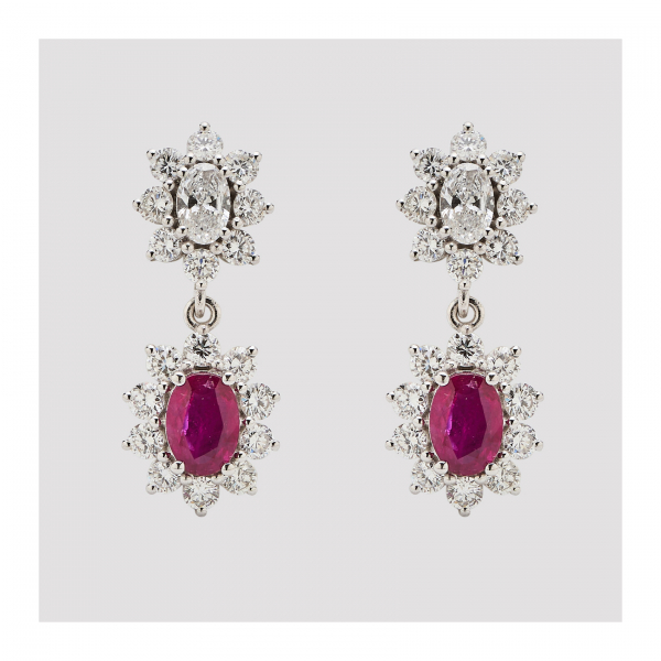 Pendientes en oro blanco formados por dos rosetones de diamantes talla brillante, uno con centro de diamante talla oval y el otro con rubí talla oval.  