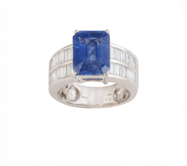 Sortija con zafiro talla rectangular de 6,44 ct en montura con dos bandas de diamantes talla baguette.   En oro blanco de 18K. 