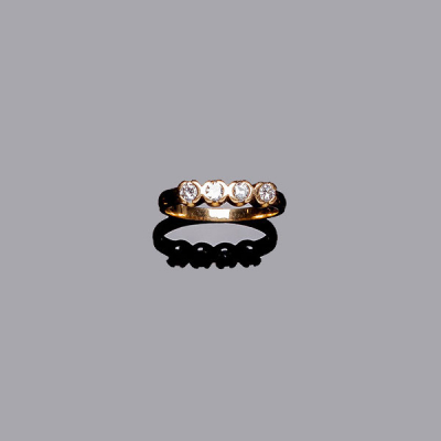 Anillo media alianza en oro amarillo, con frente en fila de limpios y blancos diamantes talla brillante, en chatones abiertos.