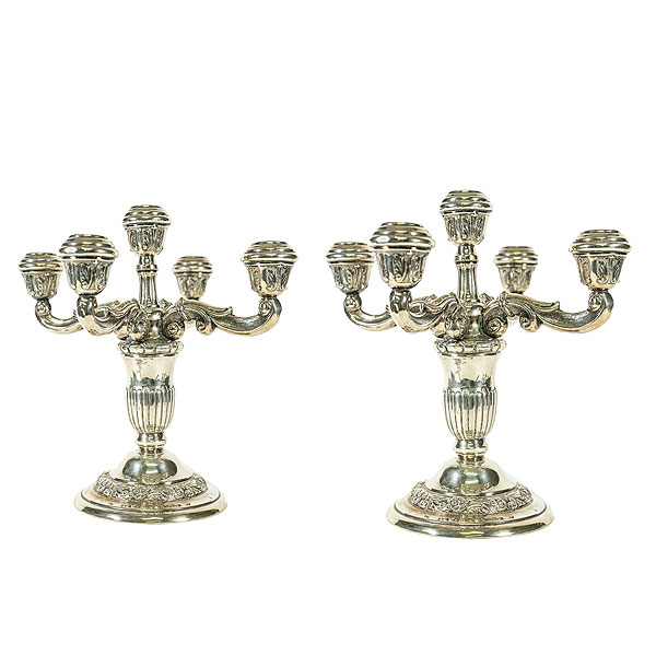 Pareja de candelabros en plata punzonada de cinco luces con decoraciones repujadas de acantos y volutas, mediados del s.XX.