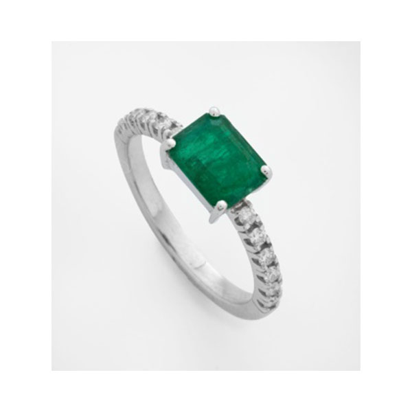 Sortija en oro blanco con esmeralda central y diamantes talla brillante a cada lado, con un peso total de 0,15 cts.aprox.
