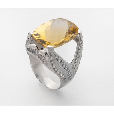 Sortija en oro blanco con topacio central y diamantes talla brillante en los brazos.