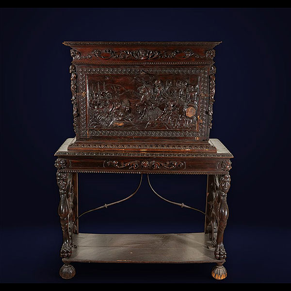Bargueño estilo renacimiento con tapa con relieves con escena belica y decoraciones de grustesco, en el interior se ven diferentes gavetas con relieves, Italia, siglo XIX.