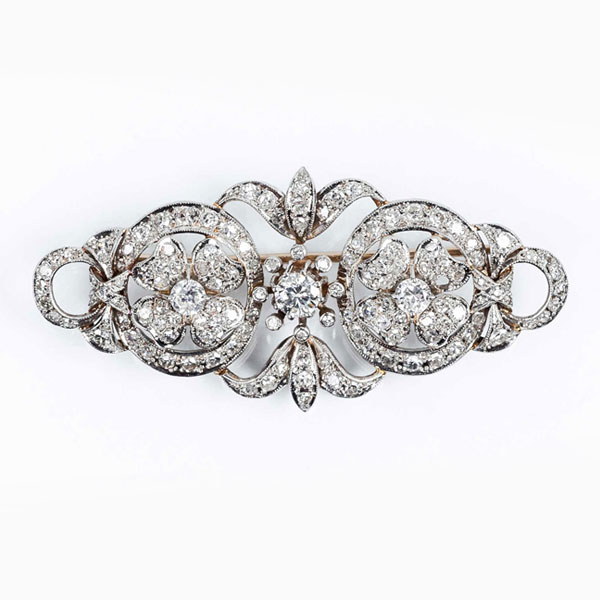 Delicado alfiler vintage en montura de oro blanco 18 K, con tres centros de limpios y blancos diamantes, talla brillante 